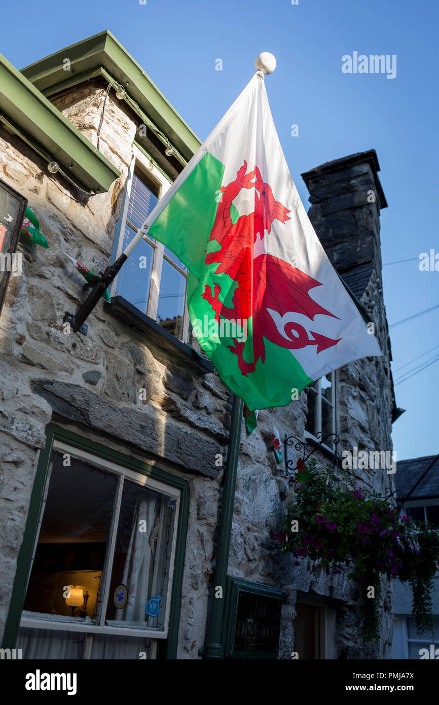 The Welsh Dragon, the national flag of Wales, hangs in evening sunshine outside the the Cross Keys pub, on 12th September 2018, in Dolgellau, Gwynedd, Wales Stock Photo