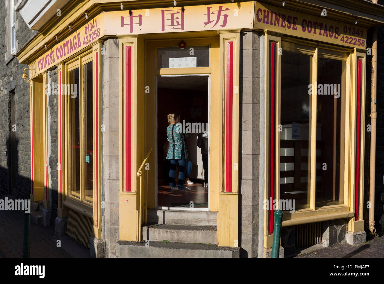 A Lady Waits For Her Order In The Chinese Cottage Takeaway On