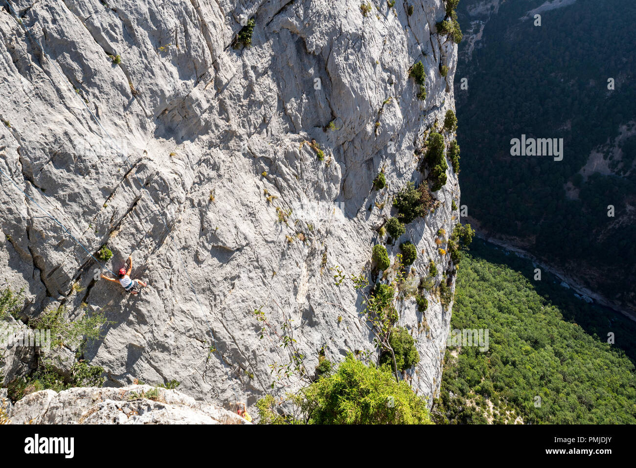 Rock climber climbing rock face in the Gorges du Verdon / Verdon Gorge canyon, Alpes-de-Haute-Provence, Provence-Alpes-Côte d'Azur, France Stock Photo