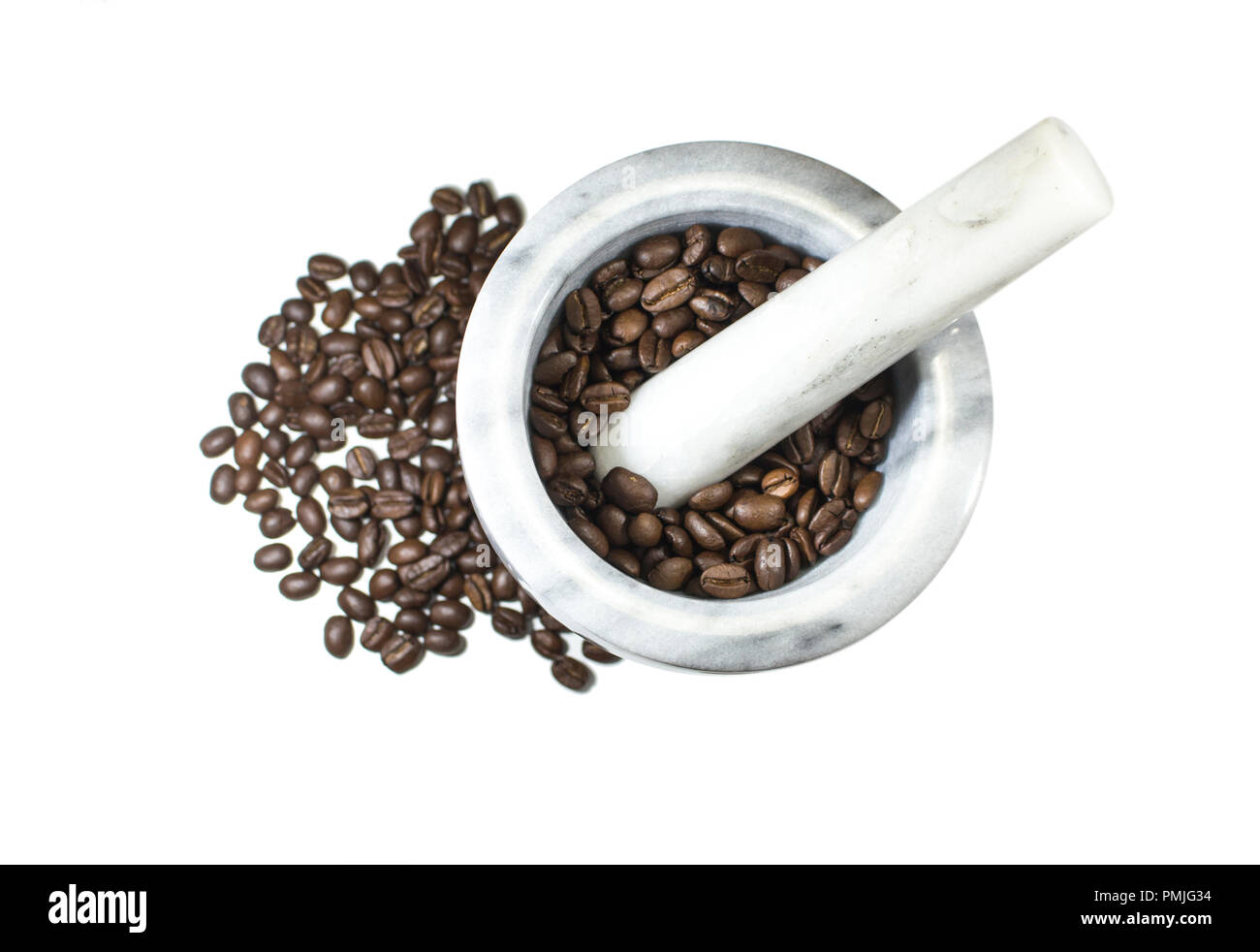 Marble mortar and pestle with roasted coffee beans inside in white