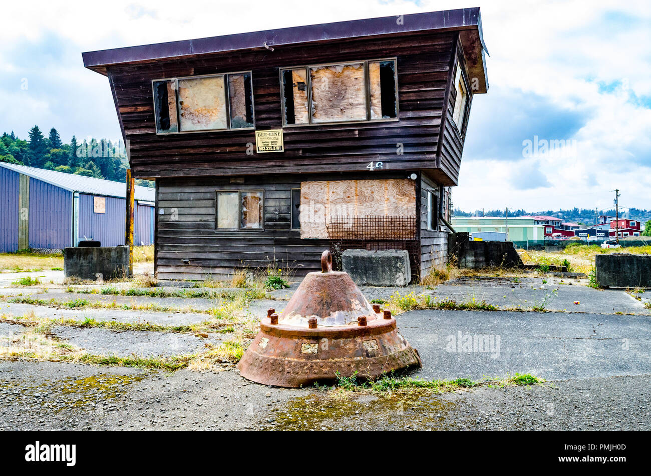 The Cast Iron Bottom Of A Harbor Buoy Sits In Front Of A Boarded