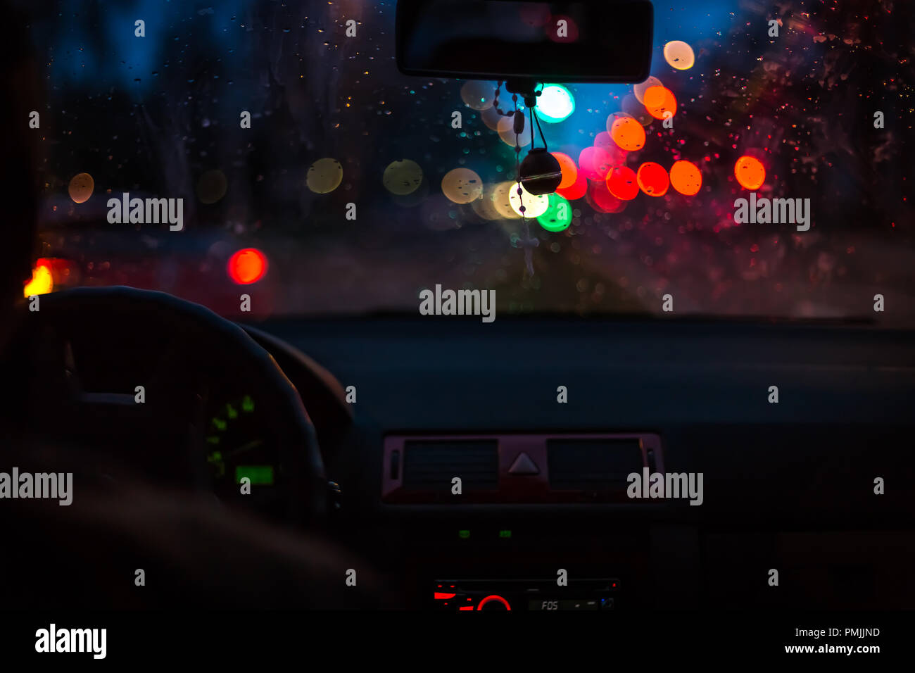 Bokeh lights from traffic on wet day. Night storm raining car driving concept. Stock Photo