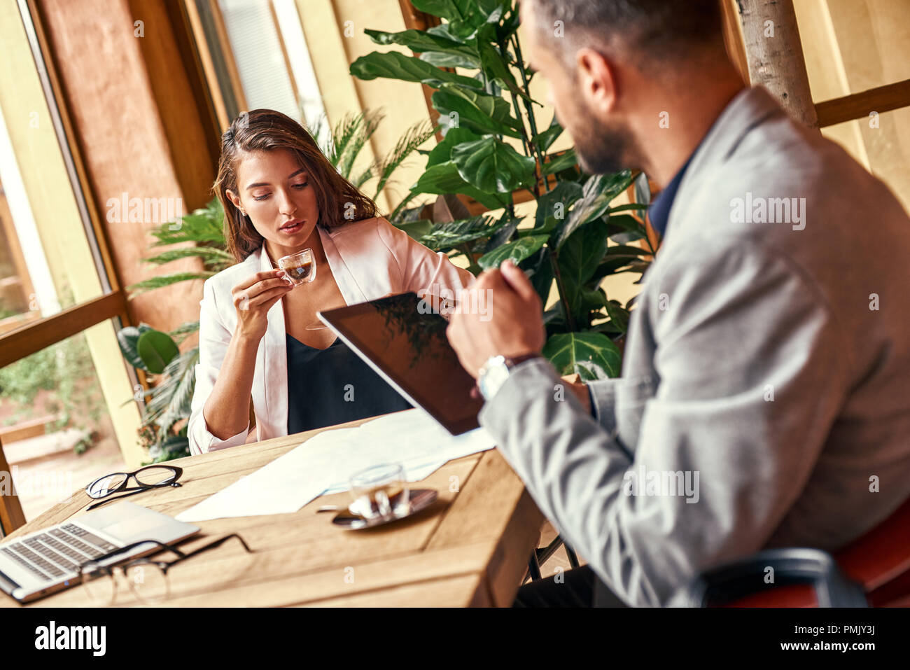 Business lunch. Business people sitting at table at restaurant drinking coffee talking close-up Stock Photo