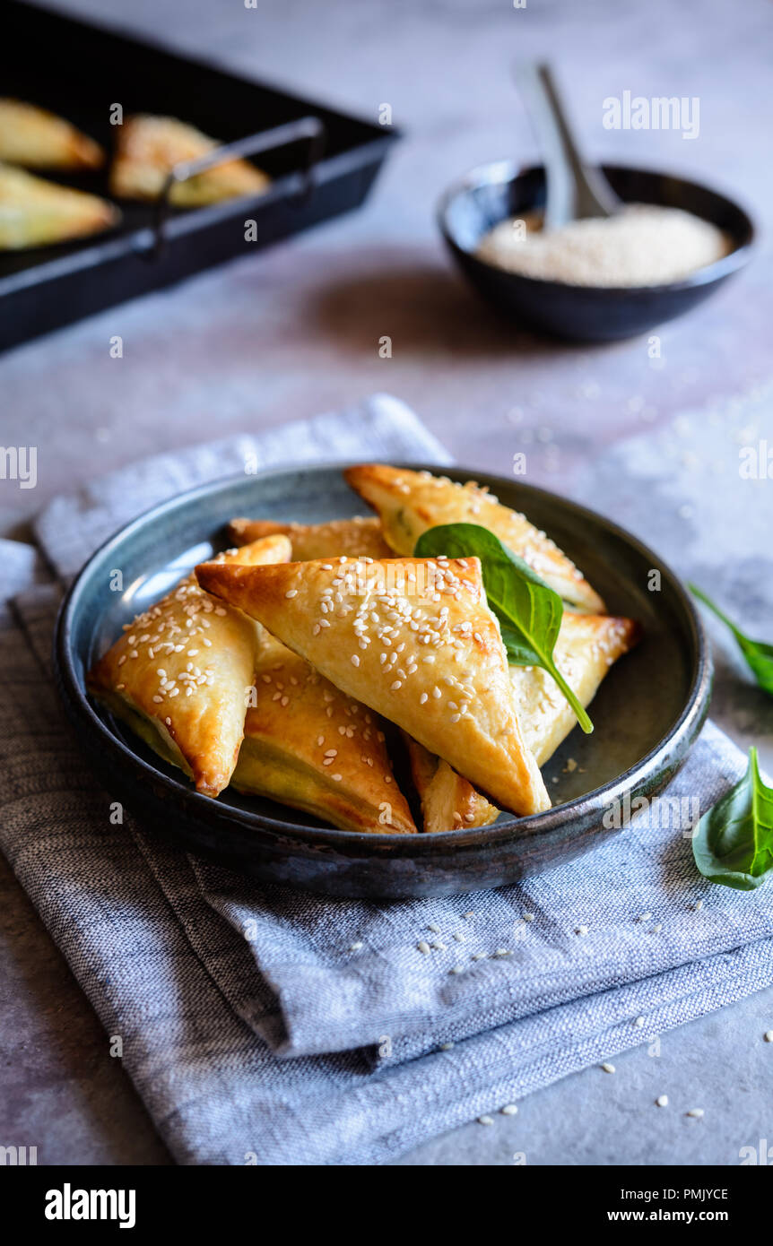 Freshly baked Spanakopita triangles stuffed with spinach and Feta cheese Stock Photo