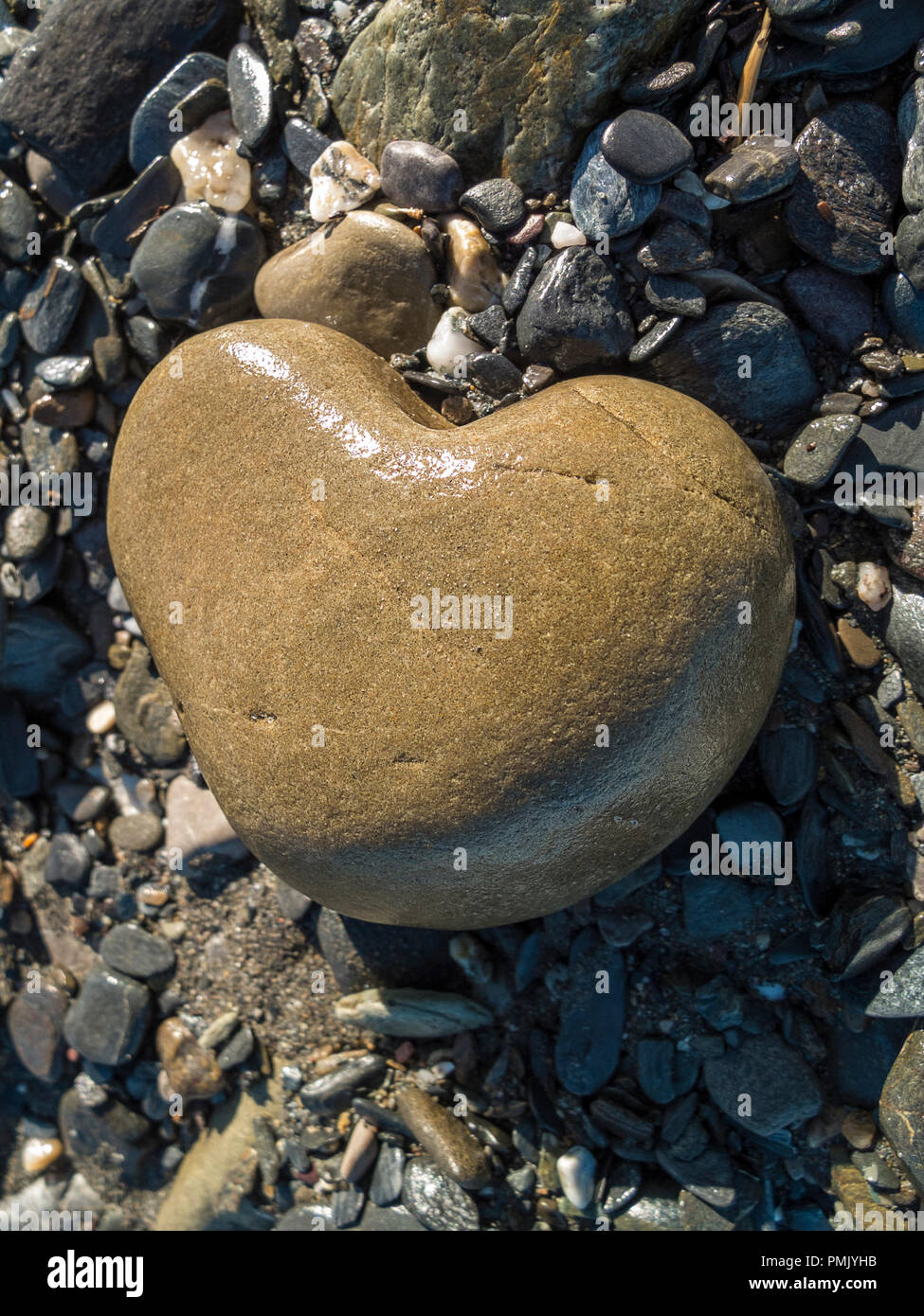 Heart shaped stone found on a rocky beach near the shore of the mediterranean sea Stock Photo