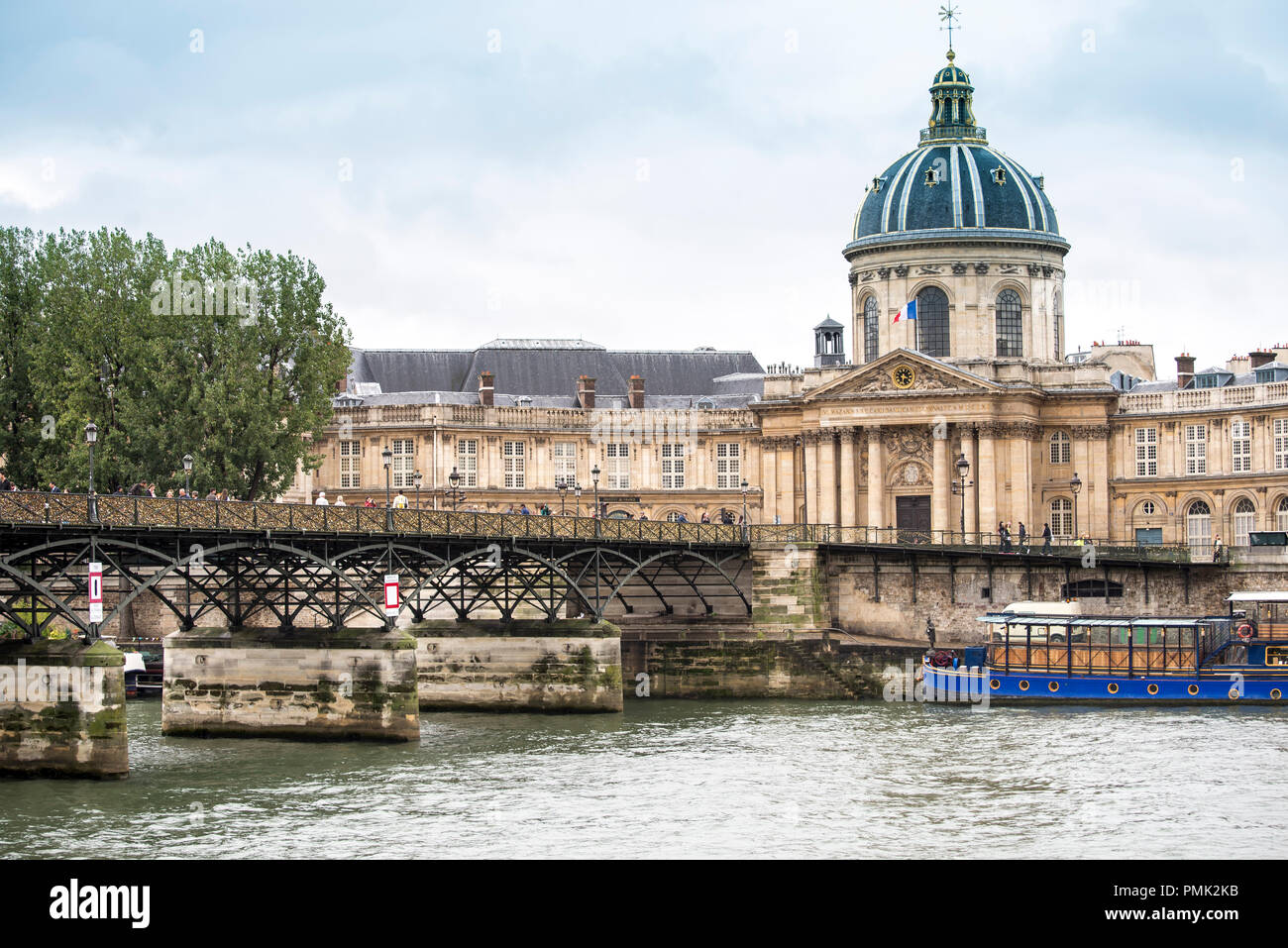 The arched metal Pont des Arts crosses the river Seine to the Institut de France in Paris France. Stock Photo