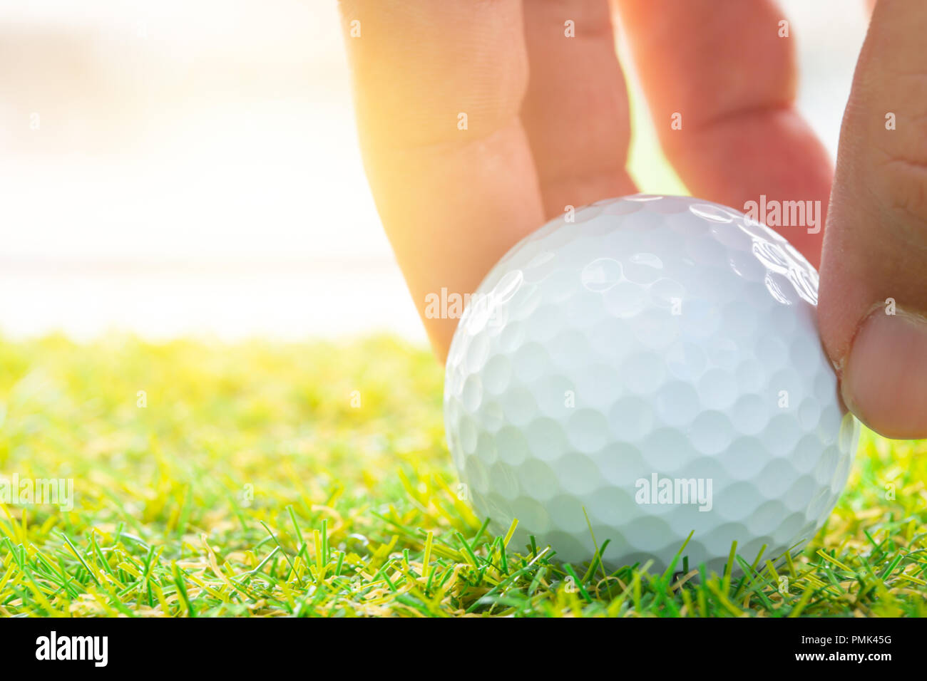 Hand place golf ball on golf course green for business startup good position to success concept Stock Photo