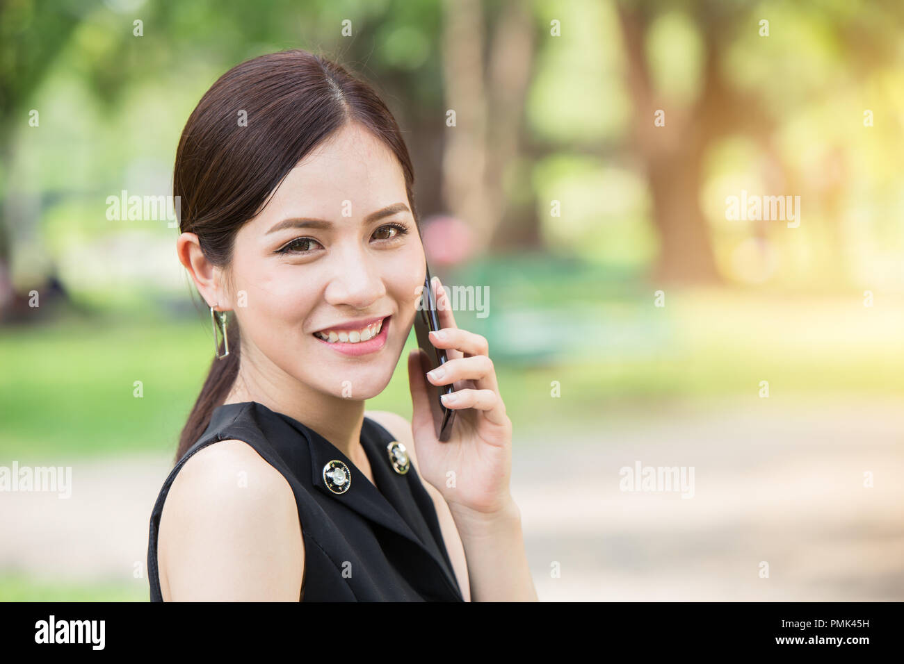 business girl calling outdoor looking camera and smile Stock Photo