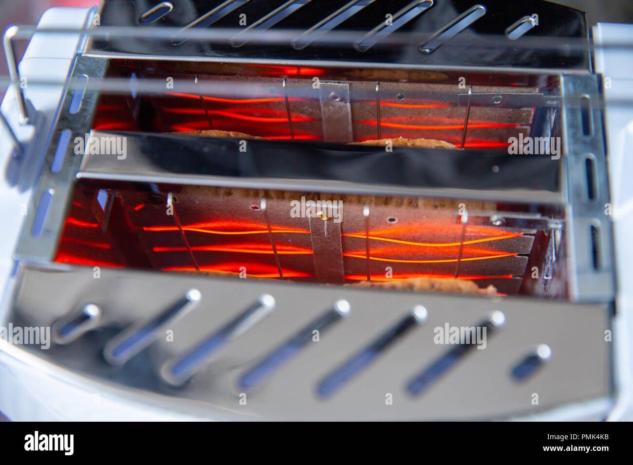 Closeup inside bread toaster heating element glowing red hot filament