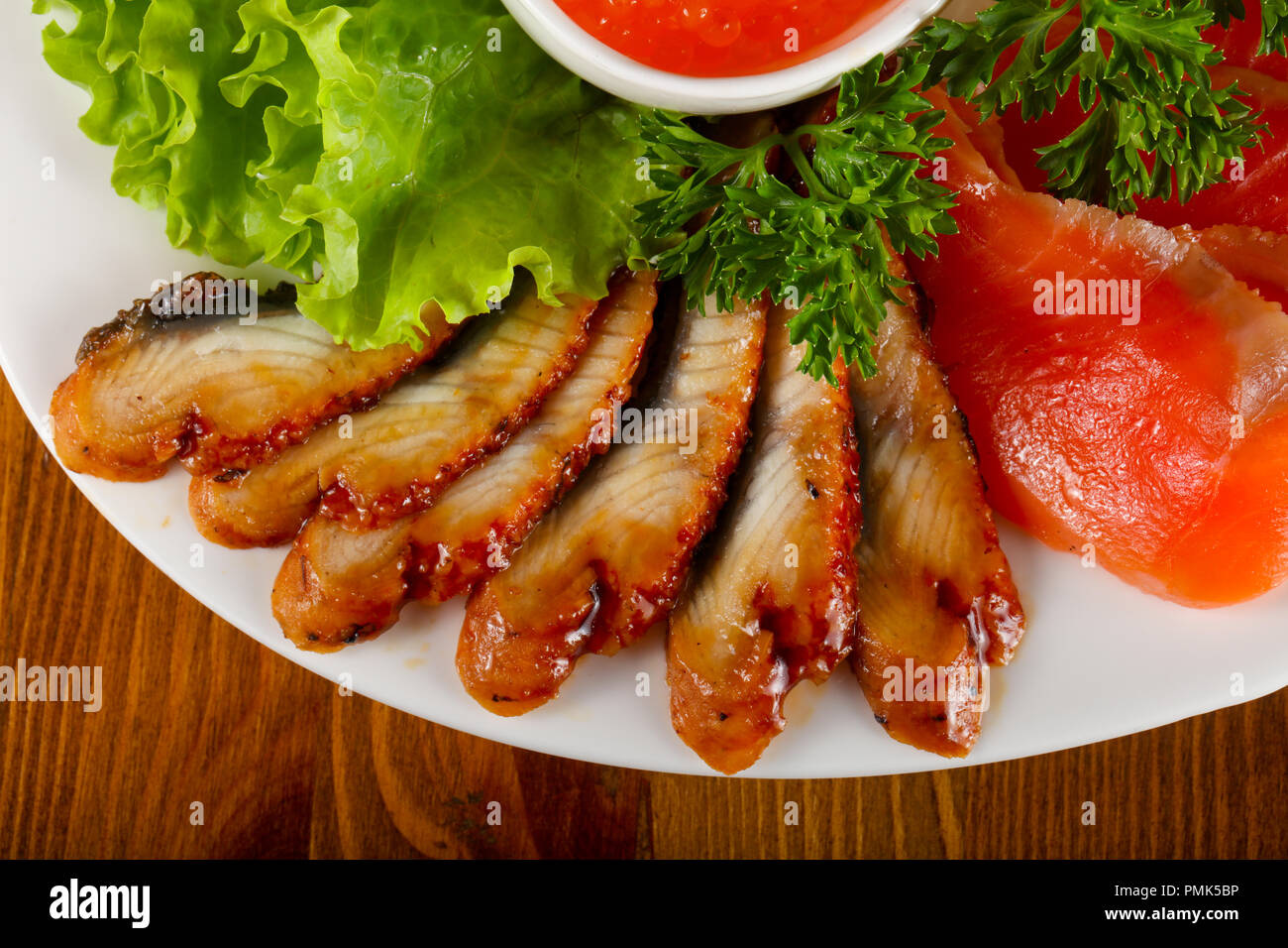 Fish plate Trout fillet, red caviar and eel served lemon Stock Photo