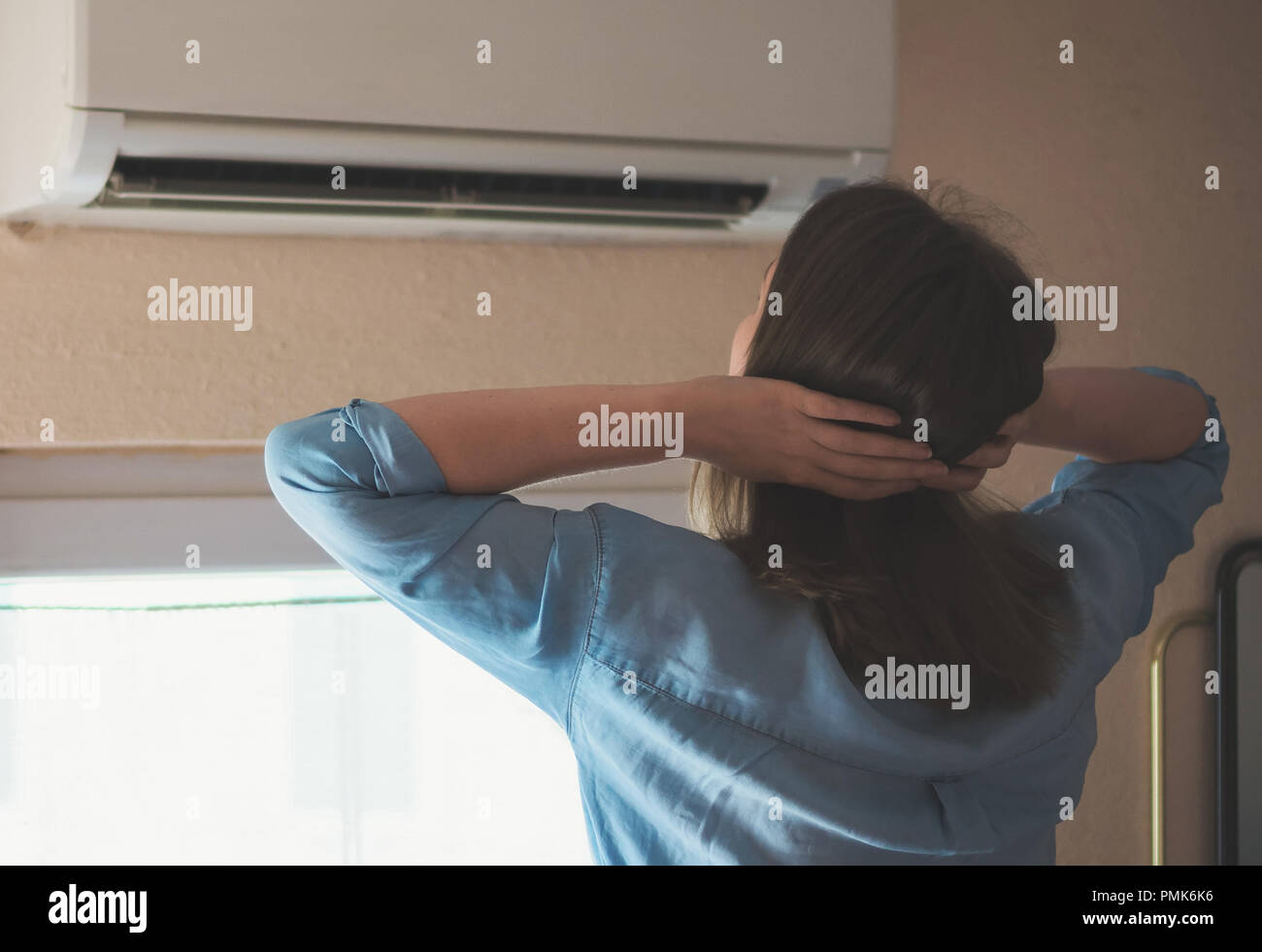 Women dying from the heat standing in front of the air conditioner