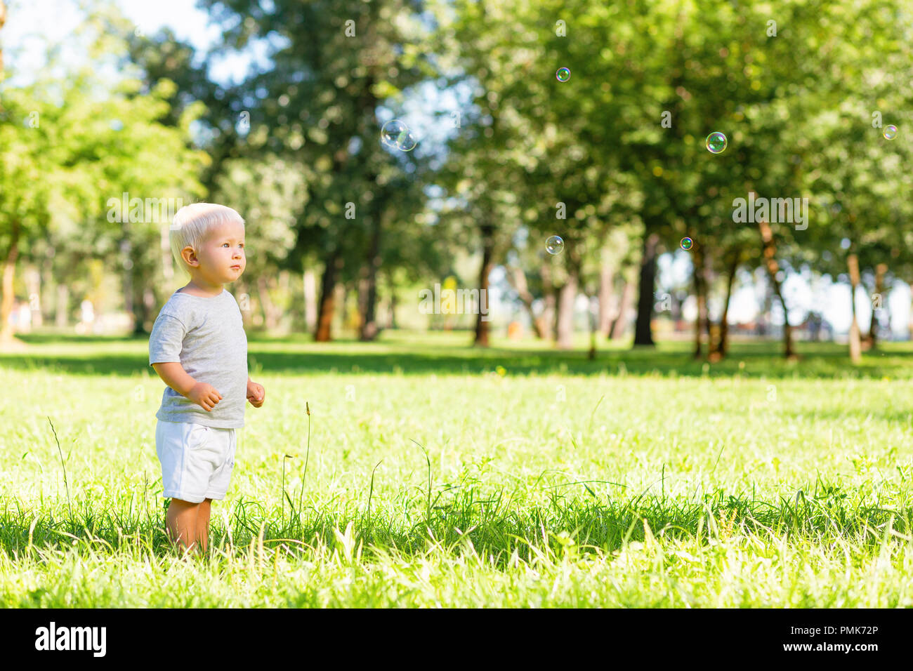 Cute small kid playing with soap bubbles in the garden Stock Photo - Alamy