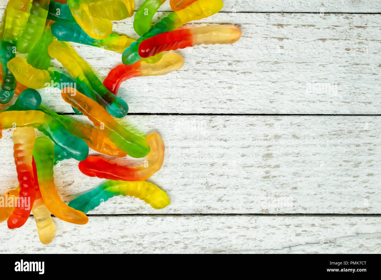 Pile of colorful gummy worms on a wooden background Stock Photo