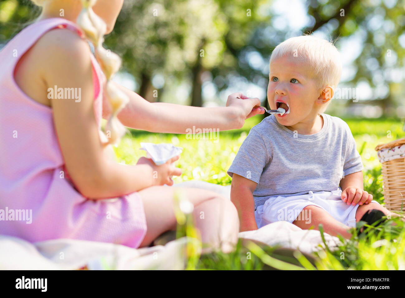 Cute kid being fed by his older sister Stock Photo