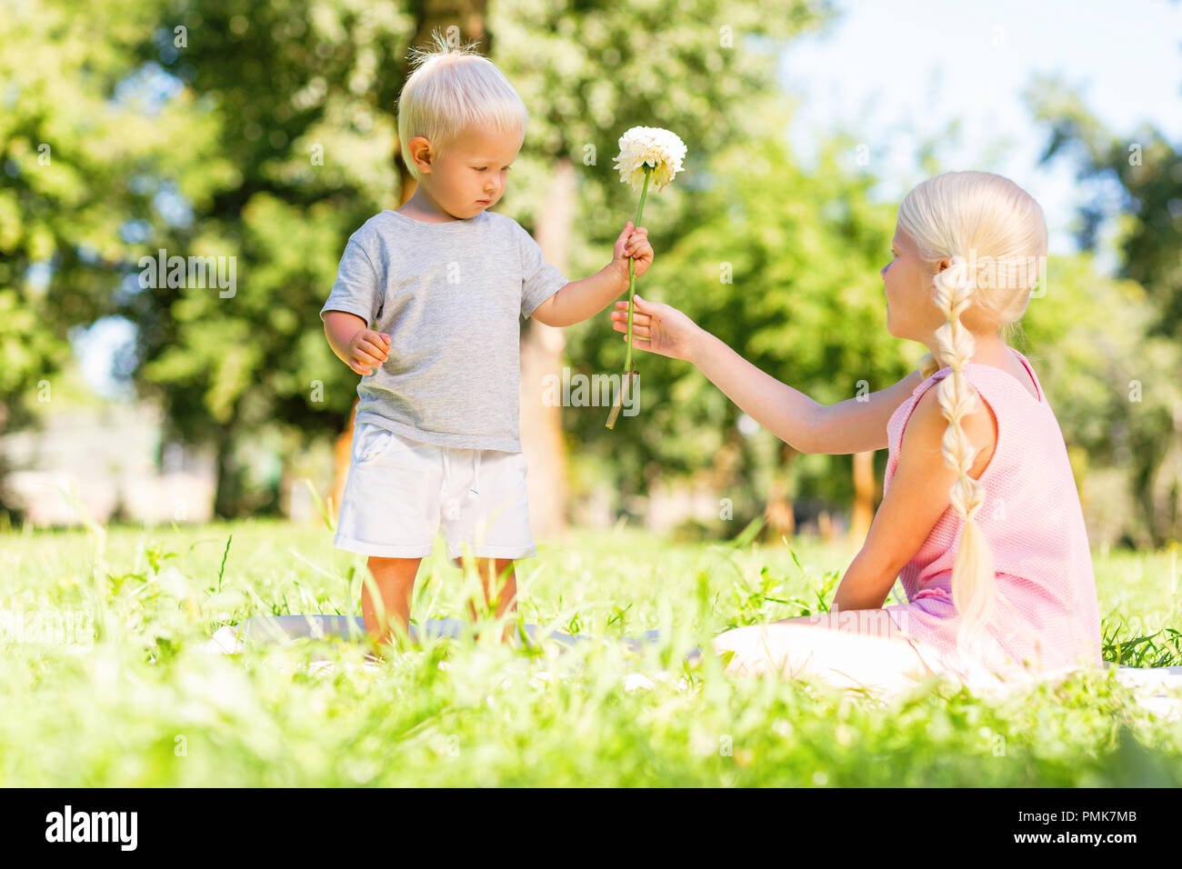 Nice girl getting a flower from a little brother Stock Photo Alamy