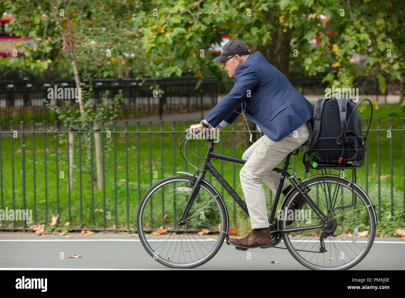 London cycling in Hyde Park UK. Individual male cyclist riding fast on the  traffic free cycling path, with large rucksack in basket in the afternoon  Stock Photo - Alamy