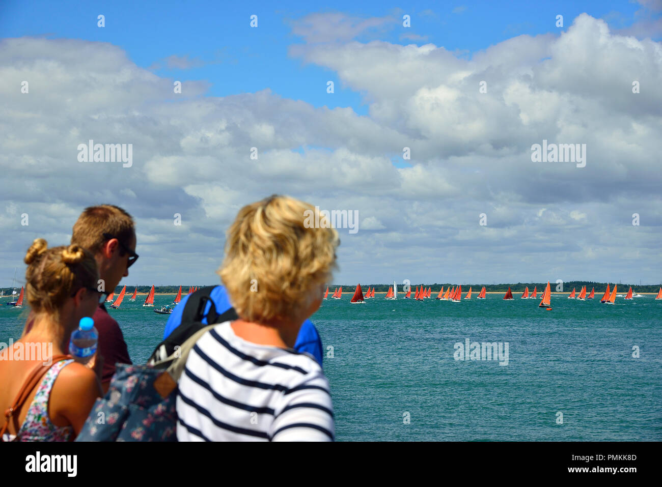Rear view of spectators watching the fleet of 100 Squibs racing in the Solent during Lendy Cowes Week (2018), Cowes, Isle of Wight, UK Stock Photo