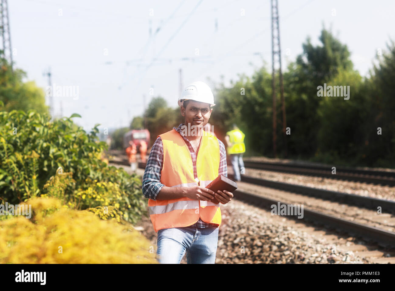 Railway engineer standing by railway tracks, Germany Stock Photo