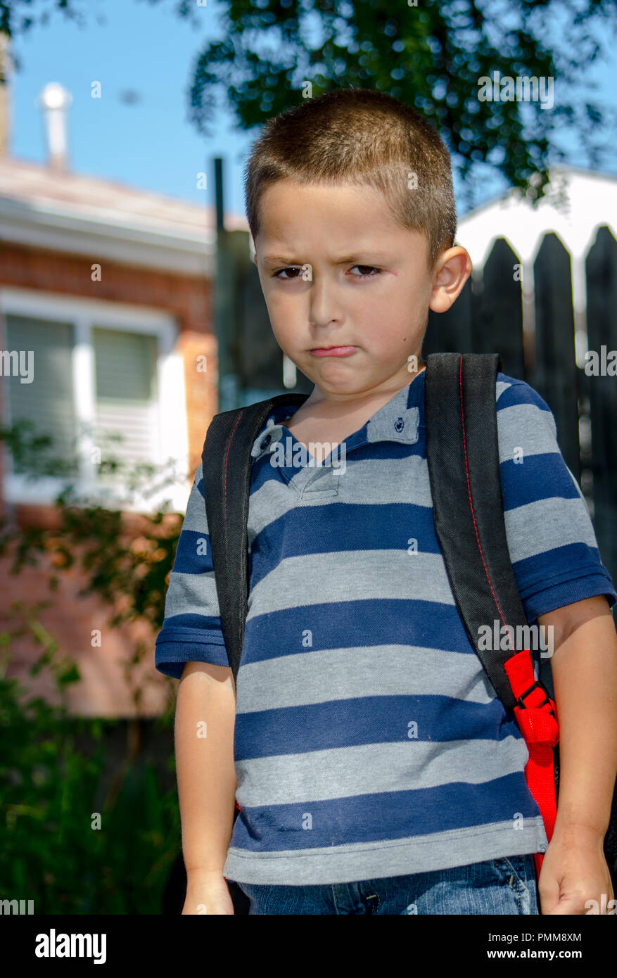 Pouting boy with back pack, not happy to go back to school Stock Photo
