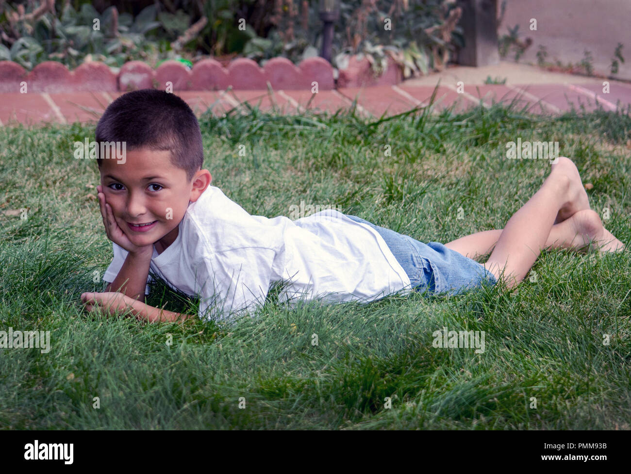 Young Latino boy laying in the grass Stock Photo