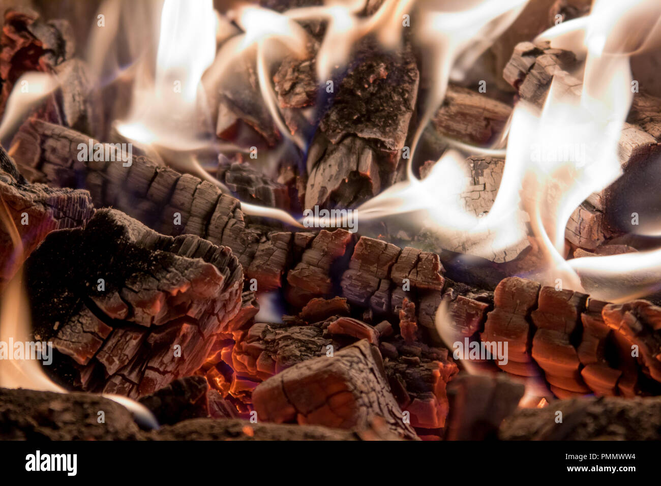 Burning firewood white coals in the fireplace background Stock Photo