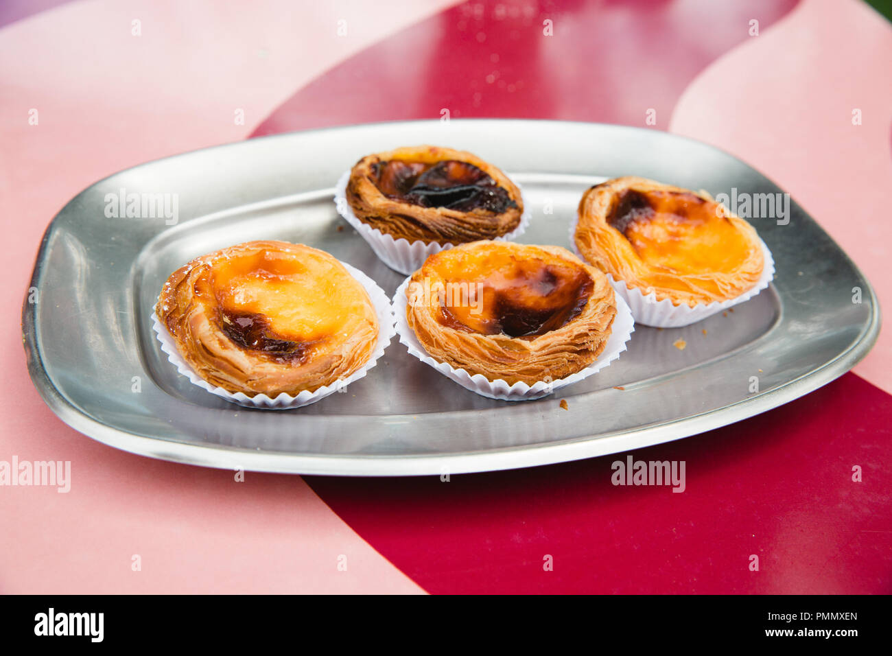 Four traditional Portuguese Pasteis de Natas (custard tarts) on a