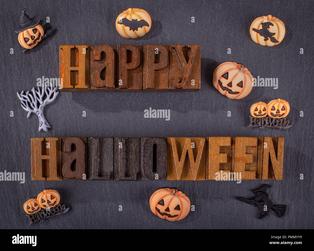 Happy Halloween wooden block text with pumpkin icons on a black background Stock Photo