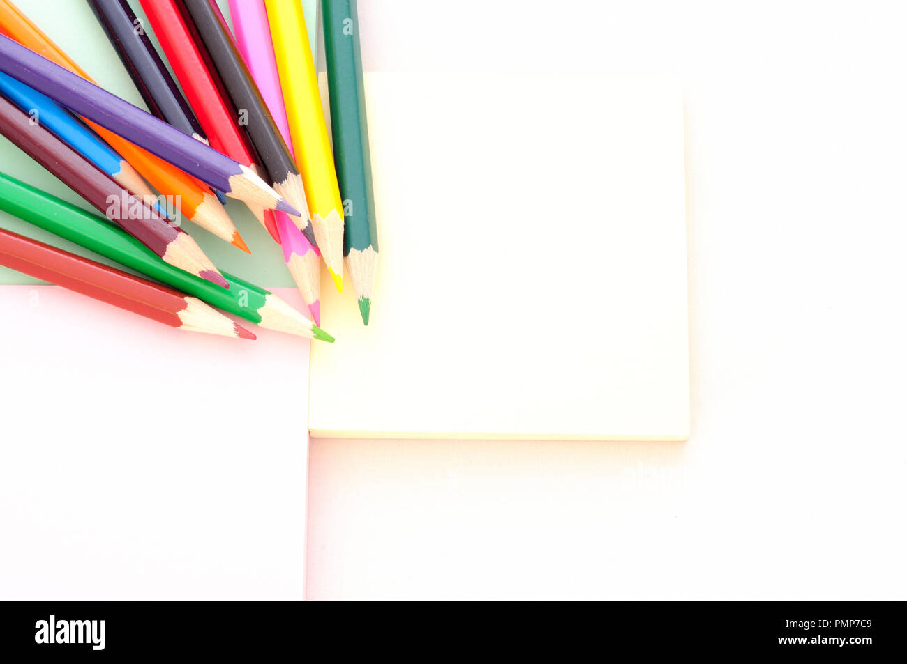 back to school, minimal background, pile of colored pencils viewed from above on a desk, large copy space Stock Photo