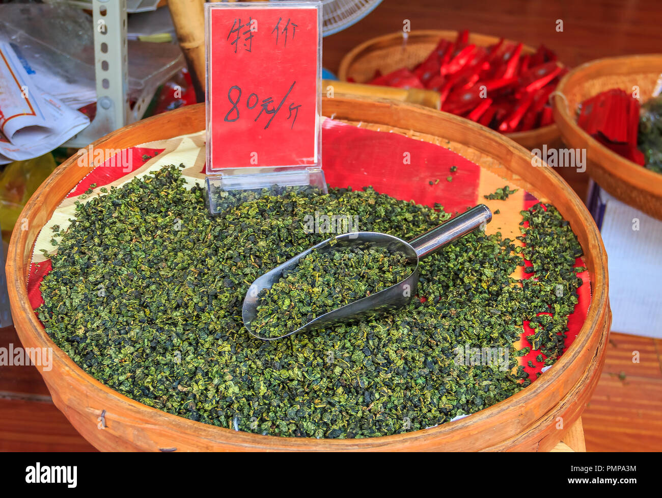 Bulk loose green tea in a bowl with a price tag for sale in bags at the