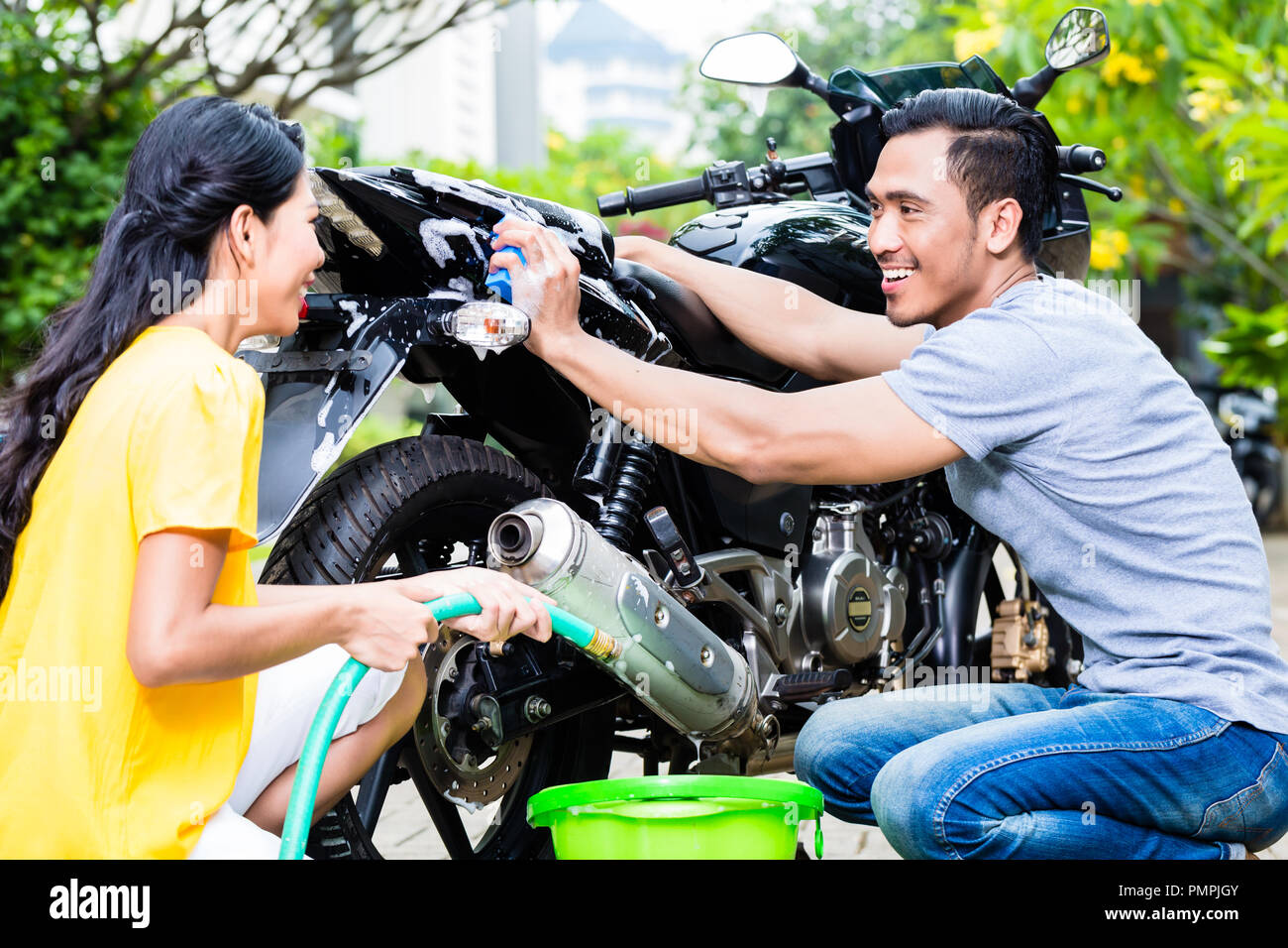 Couple washing motorcycle Stock Photo