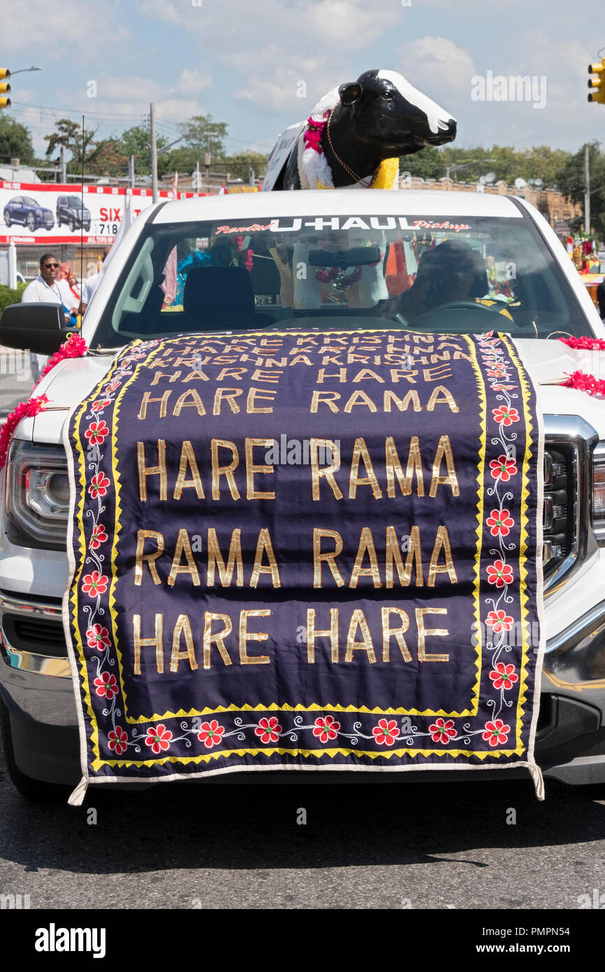 A truck carrying a statue of a cow with a Hare Krishna banner at the 2018 Madrassi Parade in Richmond Hill, Queens, New York. Stock Photo