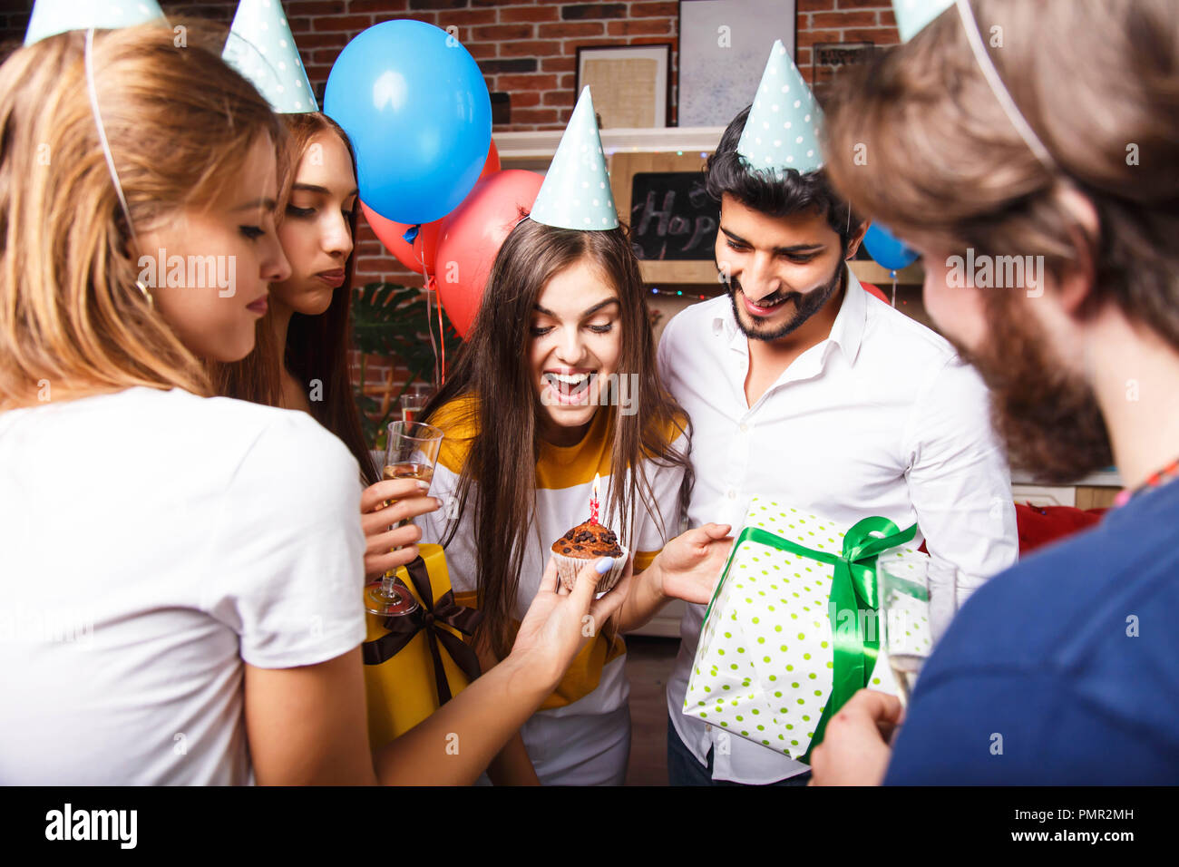 Pretty long hair birthday girl in a party hat celebrating her