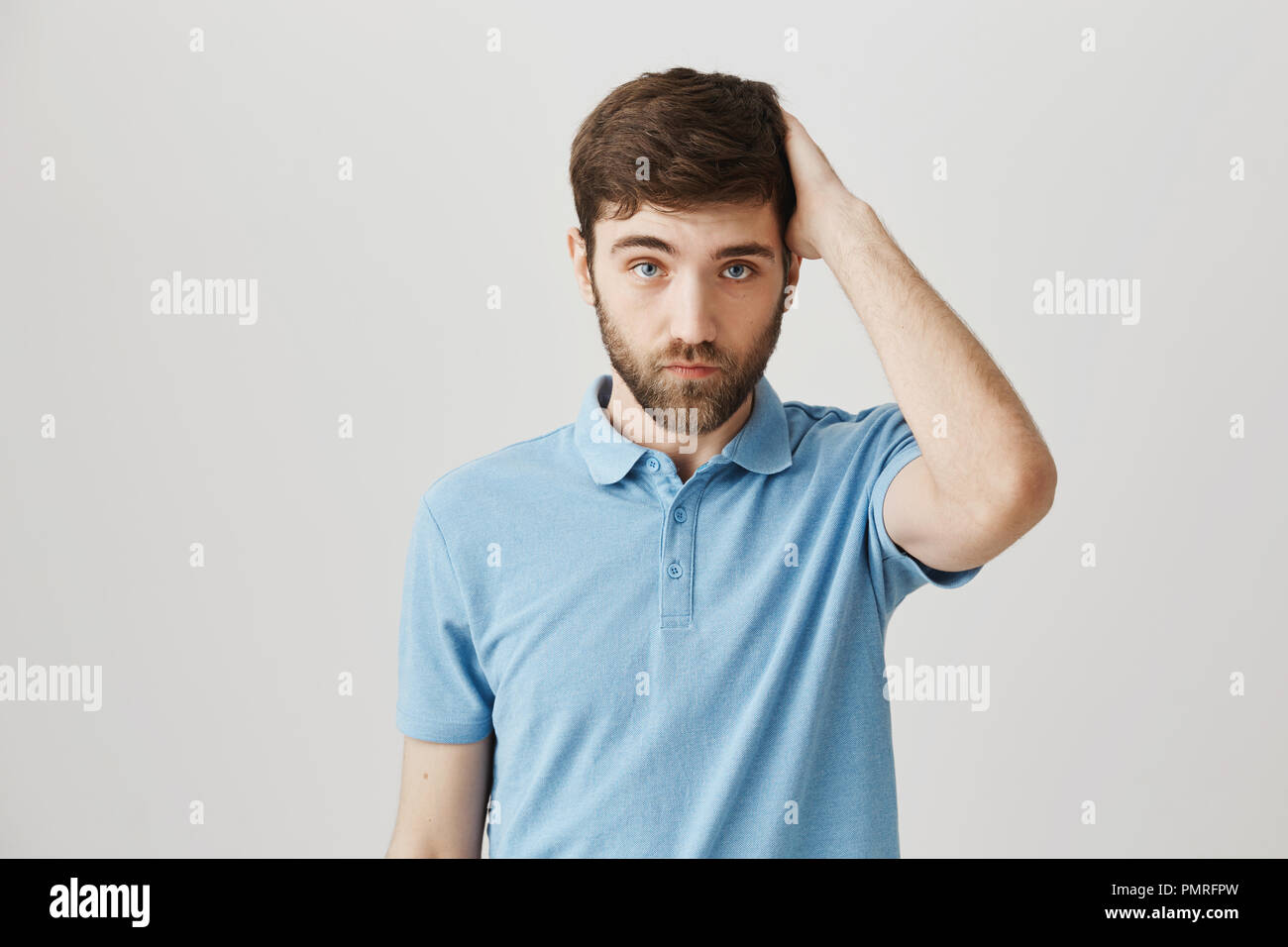 Indoor Shot Of Cute Bearded Guy With Messy Hair Holding Hand On