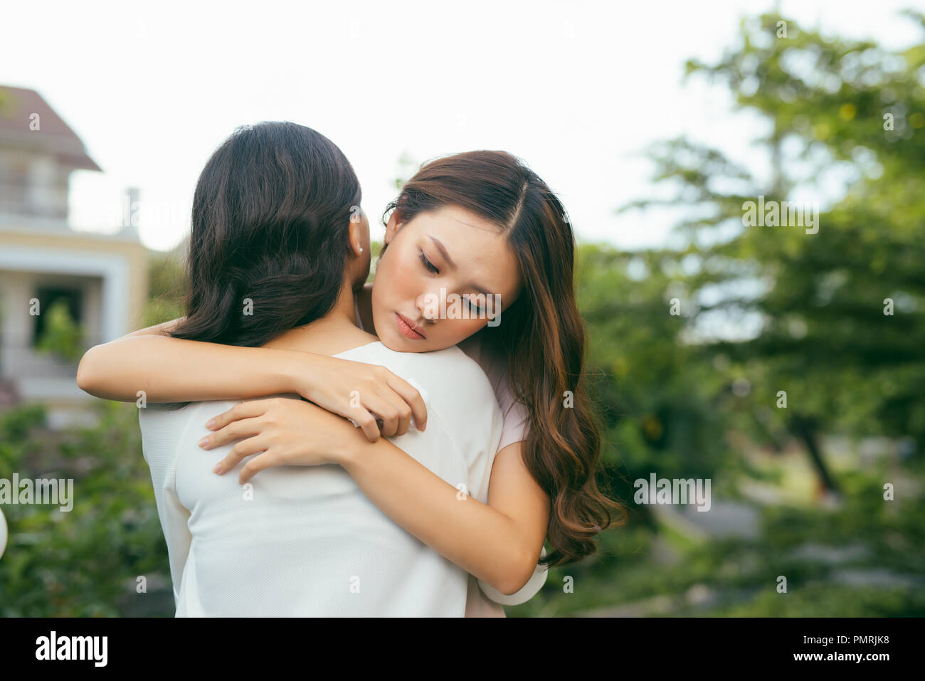 Portrait two women. Sad unhappy young woman being consoled by her friend. Friendship help support and difficult times concept. Human emotions feelings Stock Photo