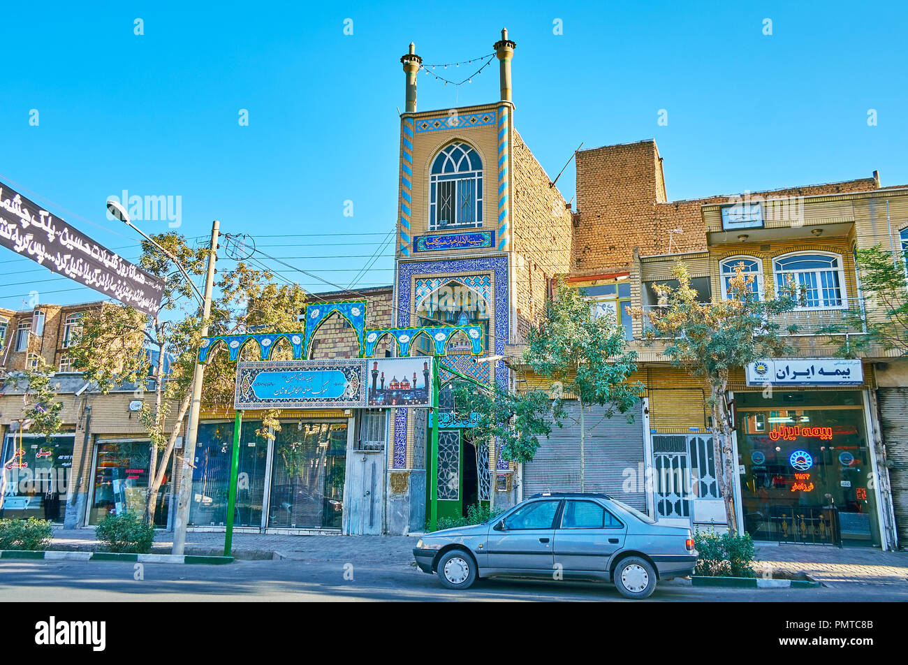 KASHAN, IRAN - OCTOBER 22, 2017: The narrow building with two tiny minarets and Islamic pattern of blue tile is Imam Hussein Hidayet Hussainiya, locat Stock Photo