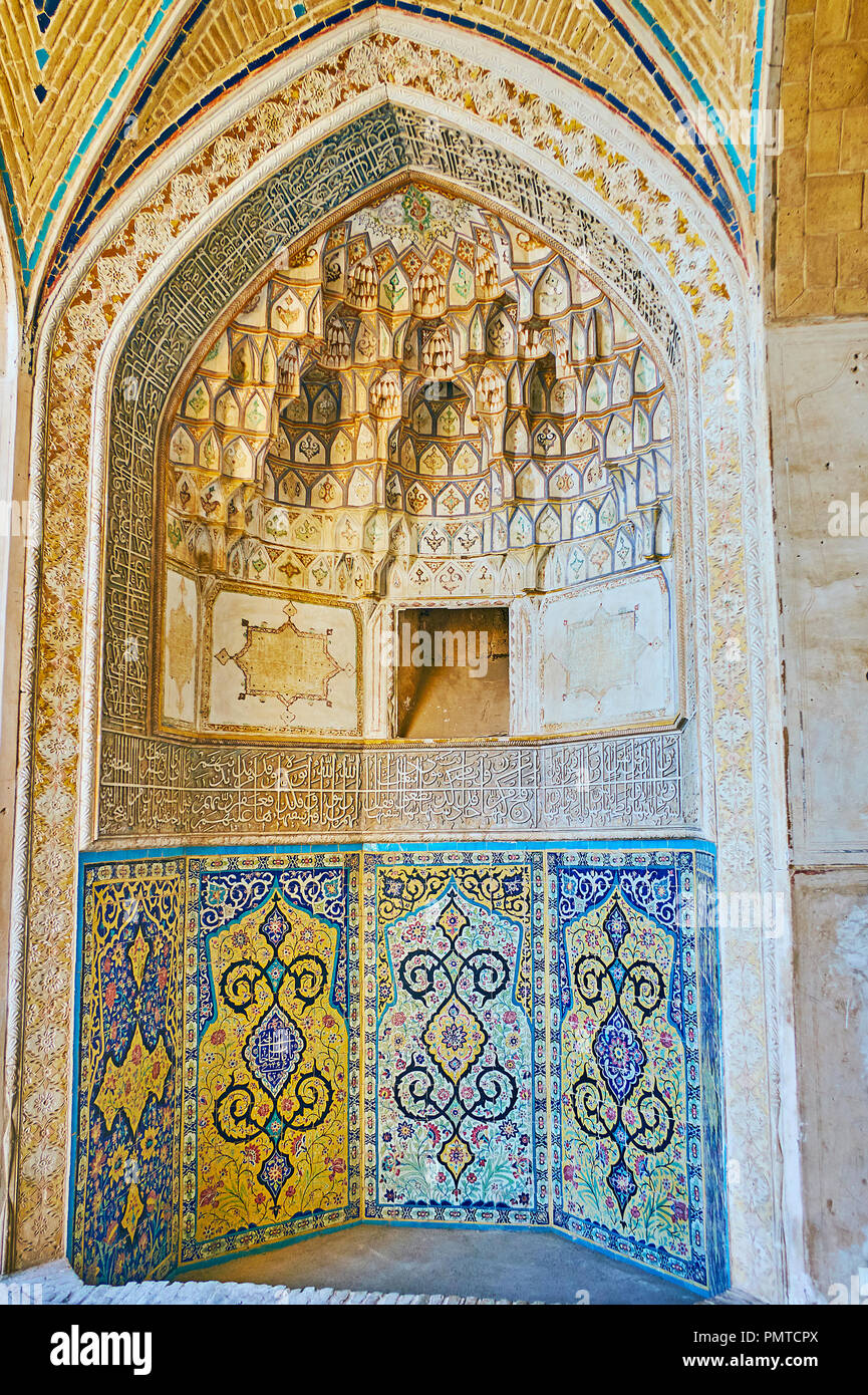 KASHAN, IRAN - OCTOBER 22, 2017: The richly decorated mihrab of Agha Bozorg mosque - the niche boasts painted arabesques, Islamic calligraphy, carved  Stock Photo