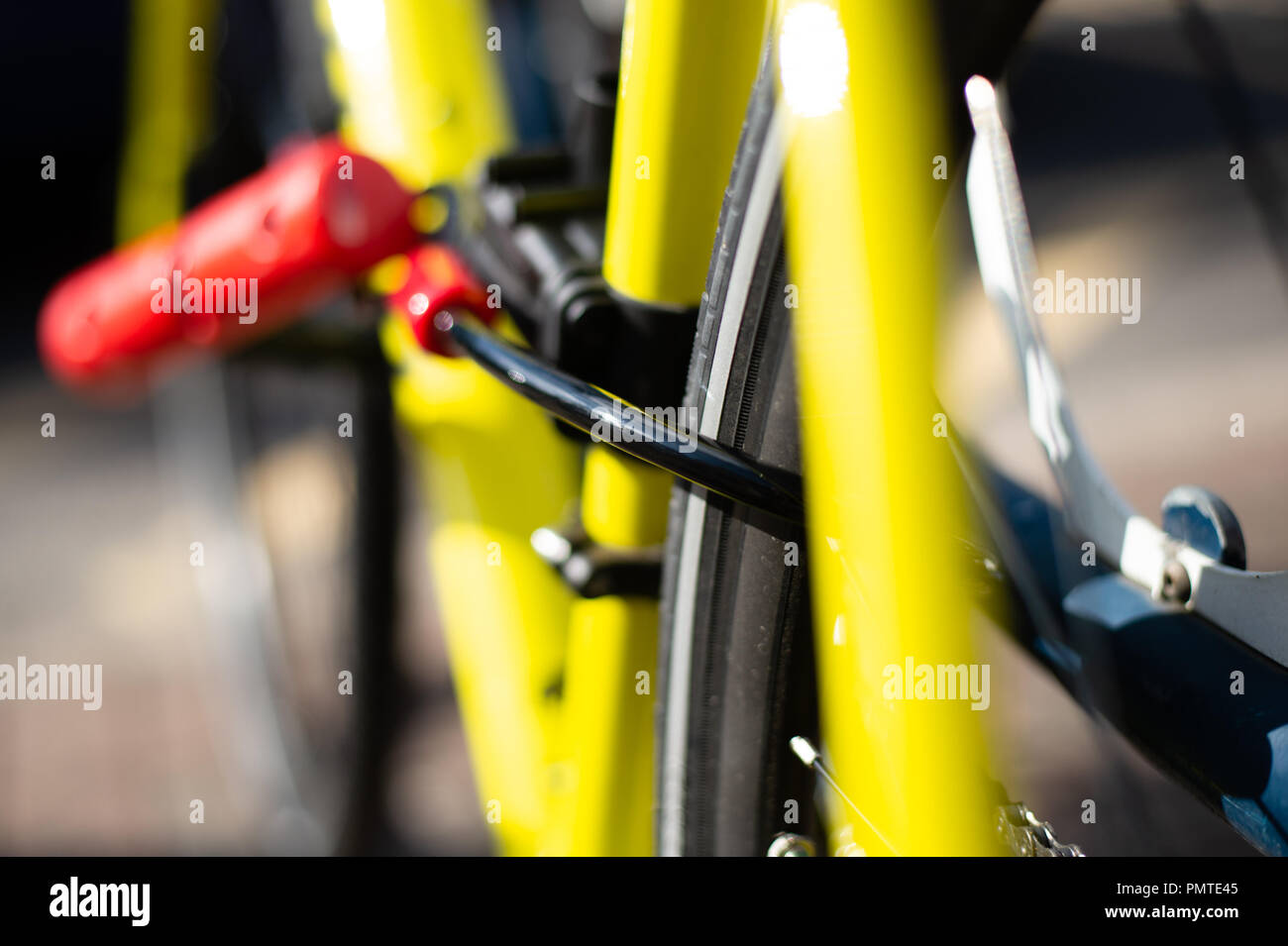 Bicycle with frame mounted U lock and cablel, secured to bike stand Stock Photo