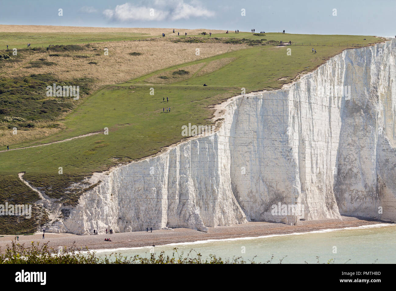 Cliffs seven sisters cliffs at seaford eastbourne UK visited by residents and tourists from far and wide.People get very close to the crumbling edges Stock Photo