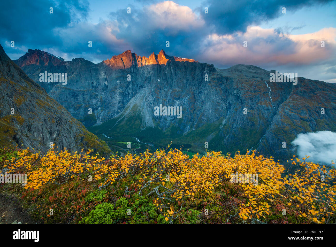 Autumn morning in Romsdalen valley, Møre og Romsdal, Norway. The sunlit mountains in the background are the 3000 feet vertical Troll Wall and the peaks Trolltindane. Stock Photo