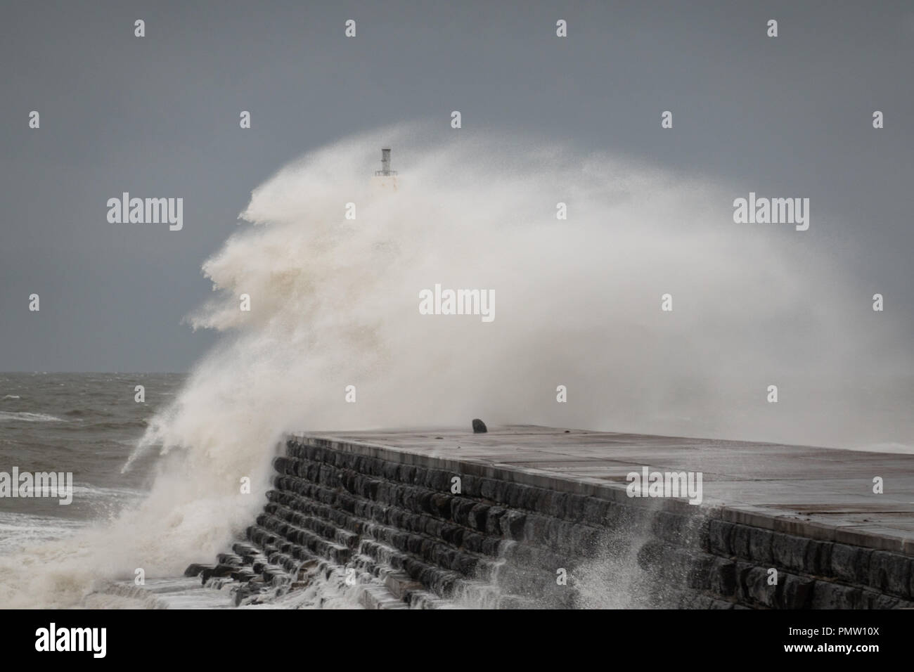 Aberystwyth, UK. 19th September 2018. Storm Ali reaches the mid Wales coast. Rough seas pound the coastline along Cardigan Bay, and big waves batter Aberystwyth harbour sea defences at high tide. Credit: atgof.co/Alamy Live News Stock Photo