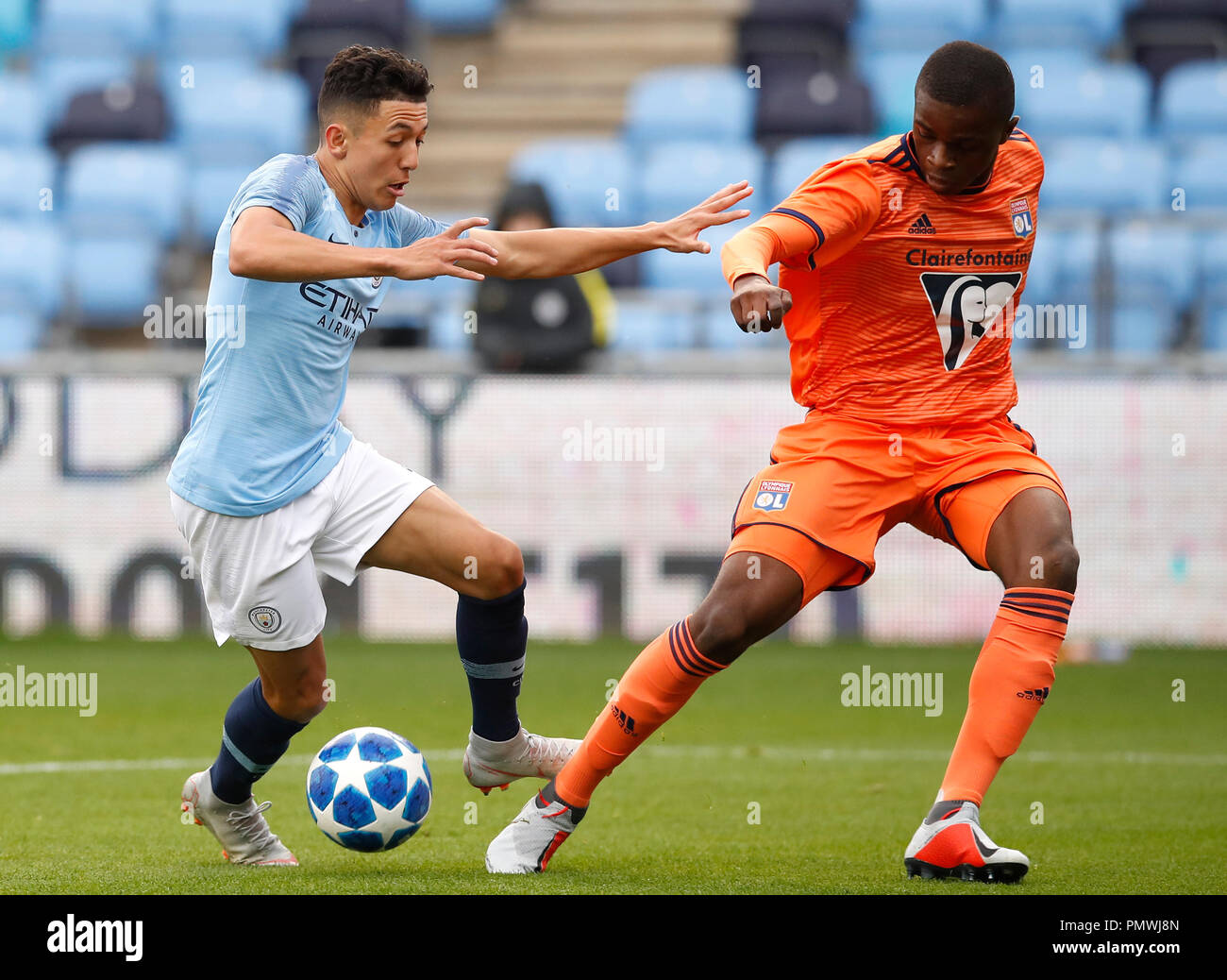 Manchester City's Ian Carlo Paveda (left) and Lyon's Pierre Kalulu battle for the ball during the UEFA Youth League, Group F match at the City football Academy, Manchester. Stock Photo