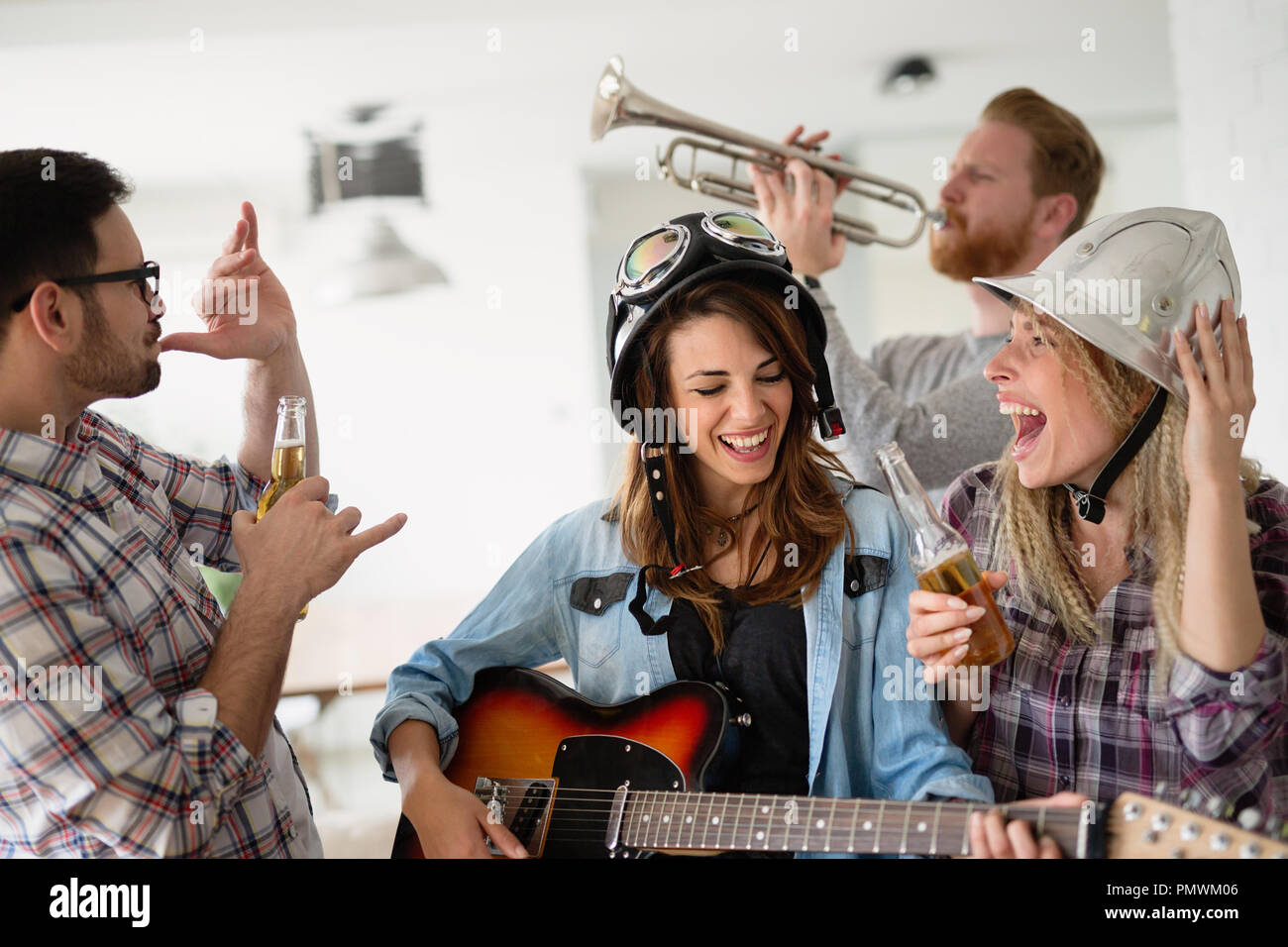 Friends having fun and partying in house and playing music Stock Photo