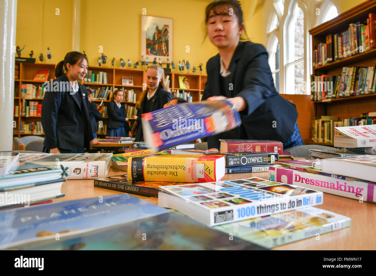 A student reaches for a book in the library at Royal High School Bath, which is a day and boarding school for girls aged 3-18 and also part of The Girls' Day School Trust, the leading network of independent girls' schools in the UK. Stock Photo