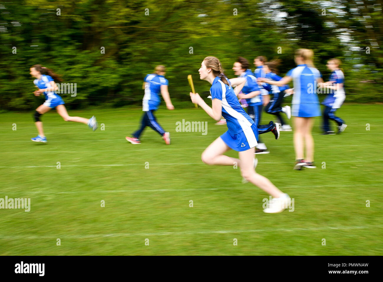 Students practice baton relay during a Physical Education (PE) lesson on the school playing