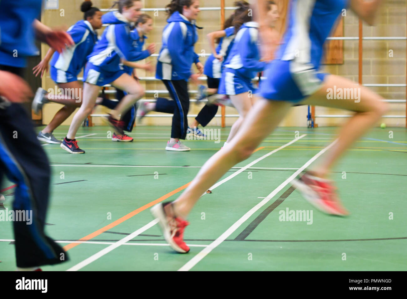 Students run during a Physical Education (PE) lesson inside the