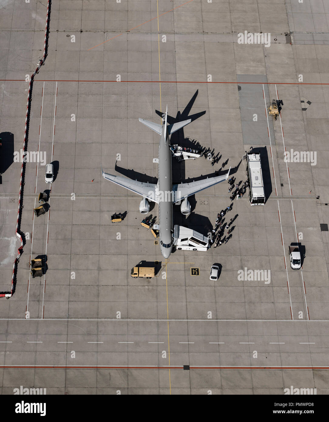 Aerial view of passengers boarding commercial airplane on tarmac at airport Stock Photo
