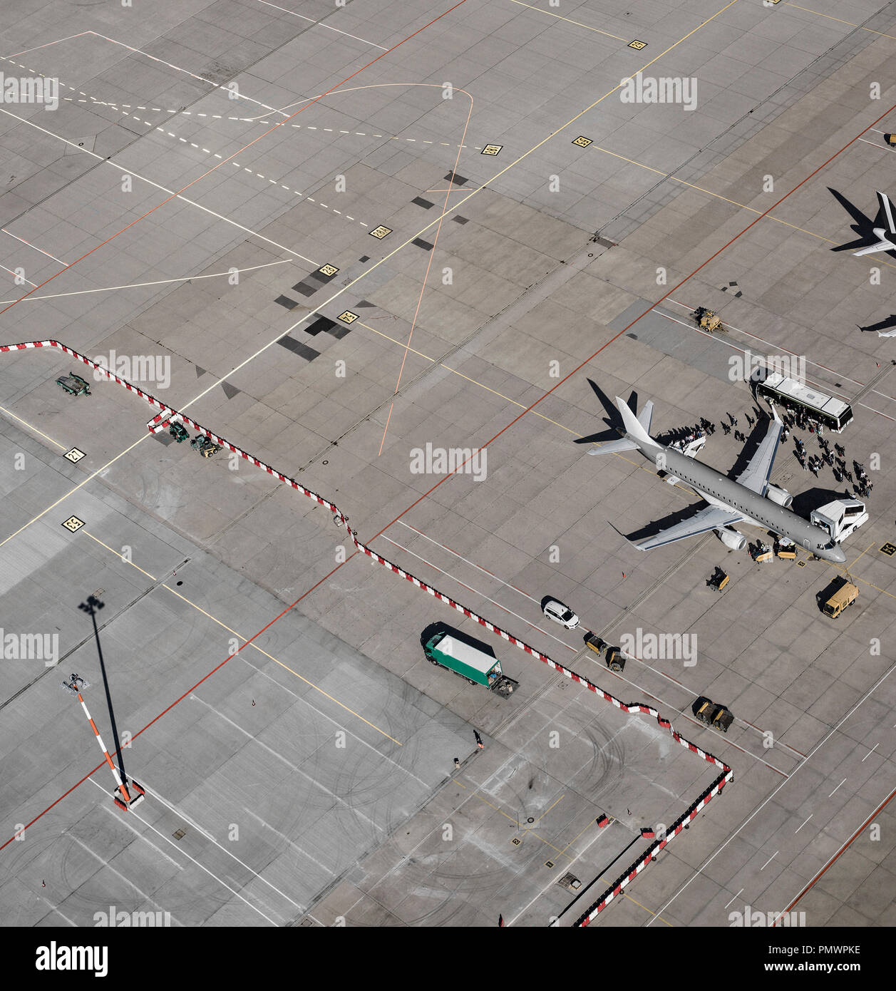 Aerial view of passengers boarding commercial airplane on tarmac at airport Stock Photo