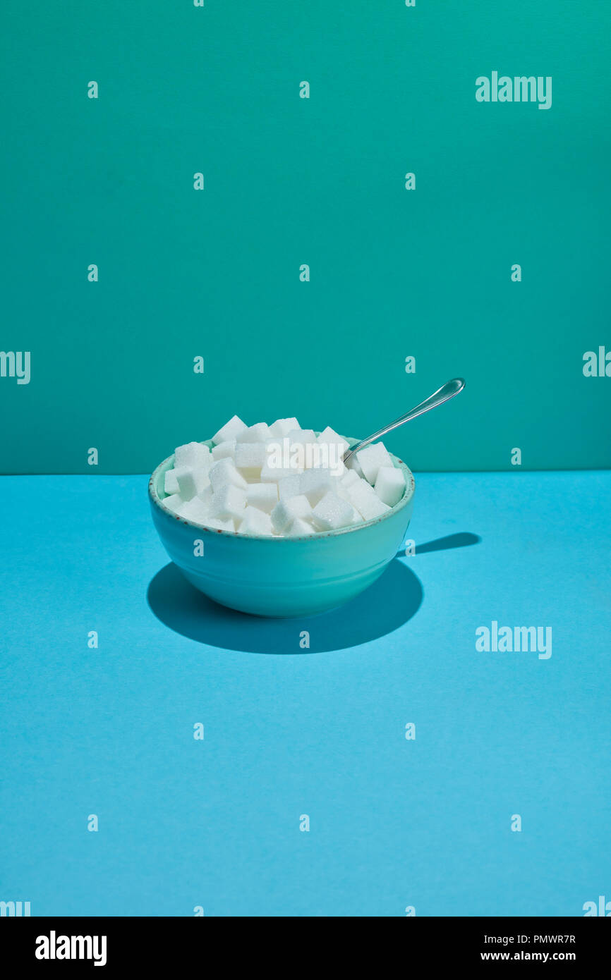 Bowl filled with sugar cubes and spoon Stock Photo