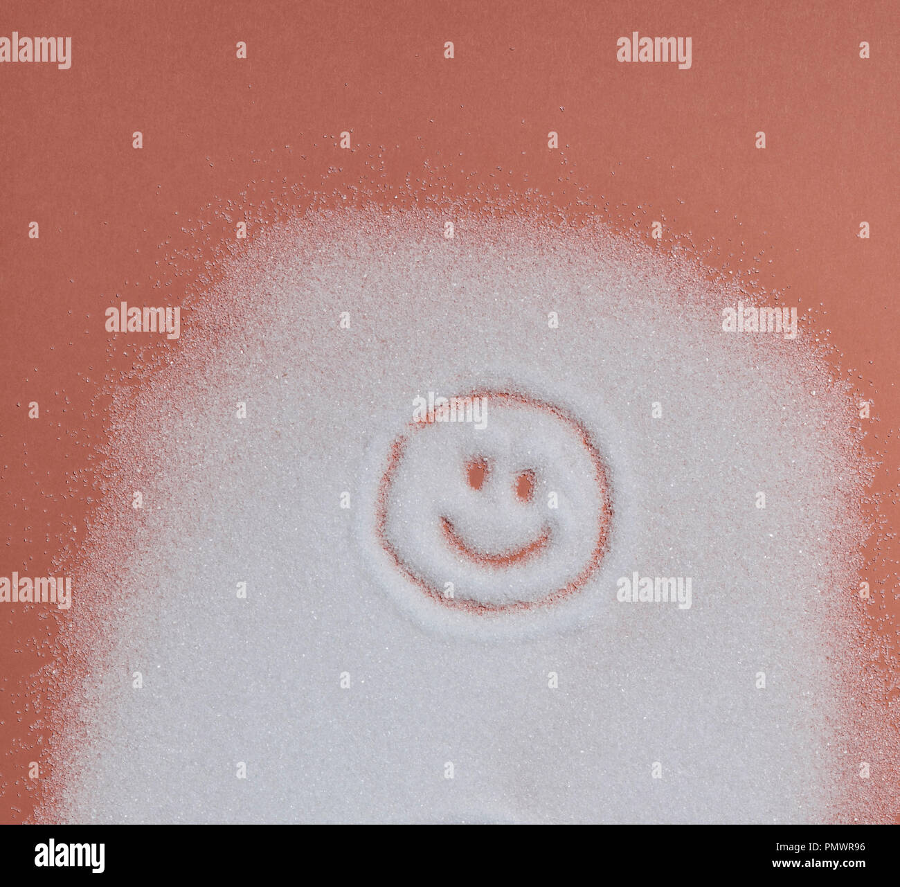 Smiley face in sugar on orange background Stock Photo
