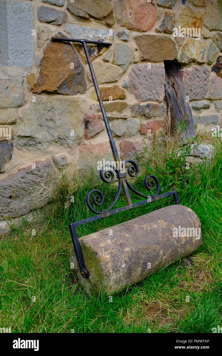Stone Grass roller outside a 17th Century cottage - Stag End Long house at Ryedale Folk Museum, Hutton le Hole, Yorkshire, UK Stock Photo